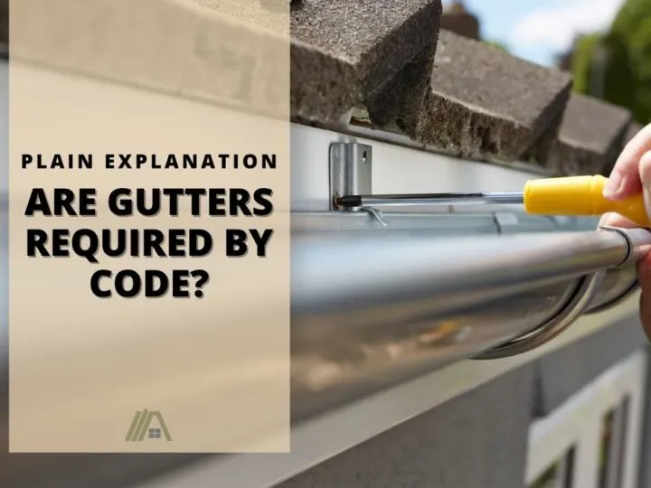 Hand holding a yellow handled screwdriver installing a gutter; Are Gutters Required By Code? (Plain English Explanation)