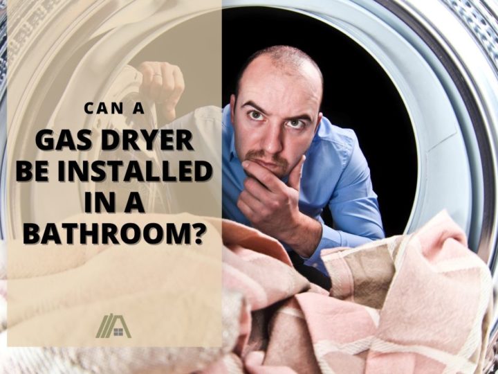 Man with a wondering look, looking into a dryer; Can a Gas Dryer Be Installed in a Bathroom?