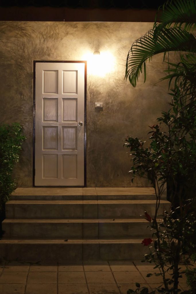 Entrance of a house at night with a back door facing a short staircase