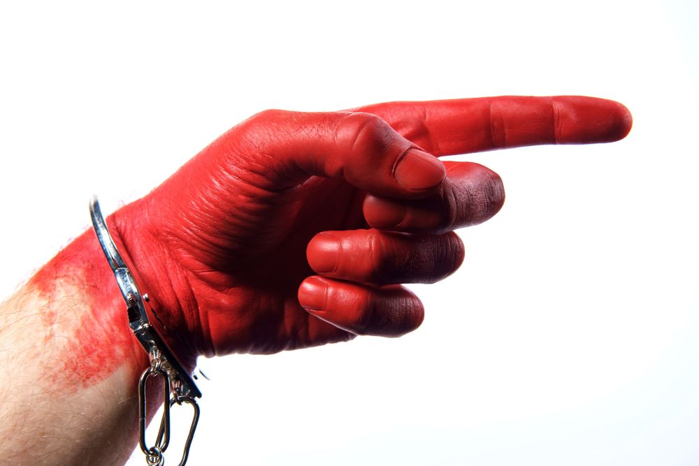 Caught red handed - hand painted red wearing handcuffs concept