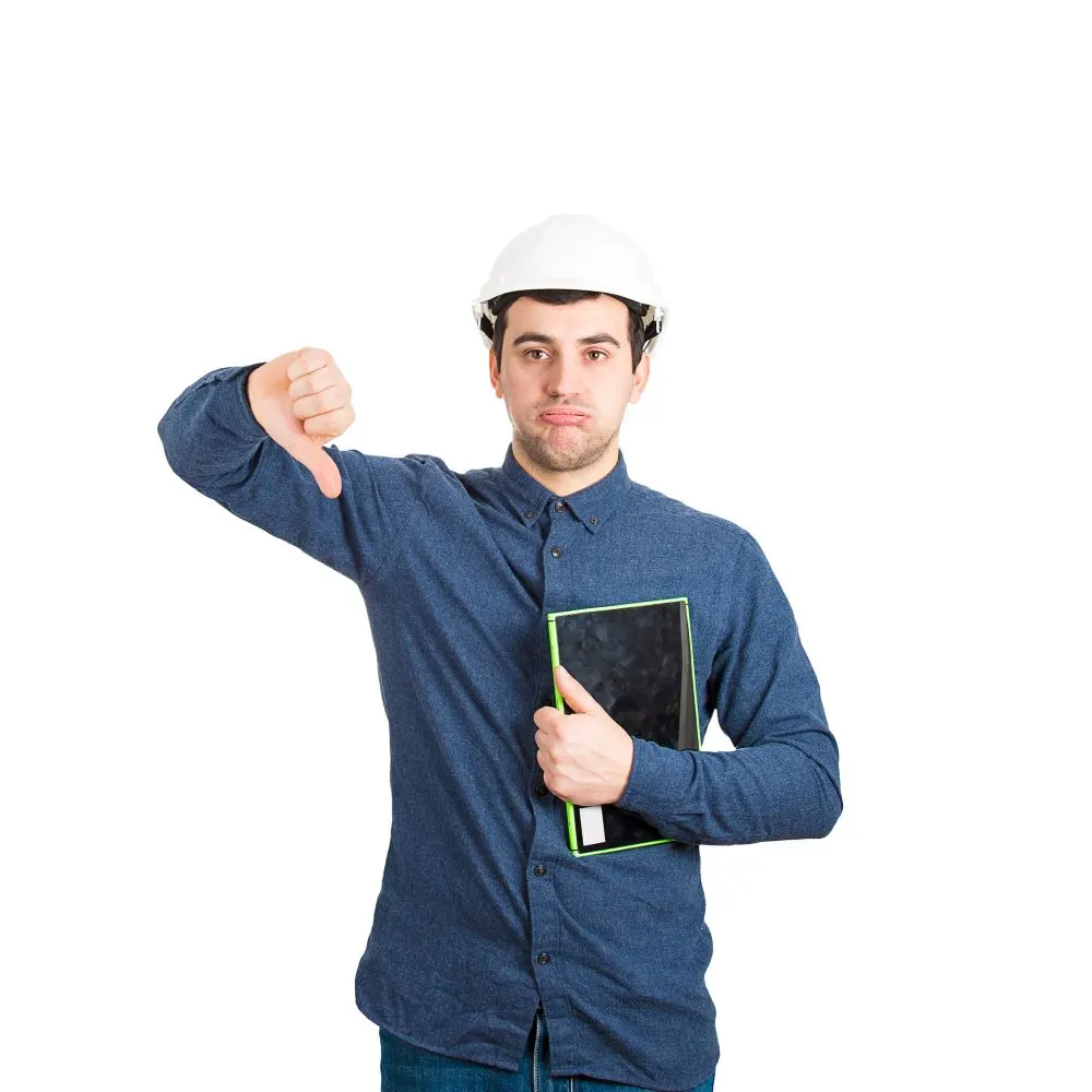 young man engineer wearing protective helmet holding tablet computer showing thumb down negative feedback gesture