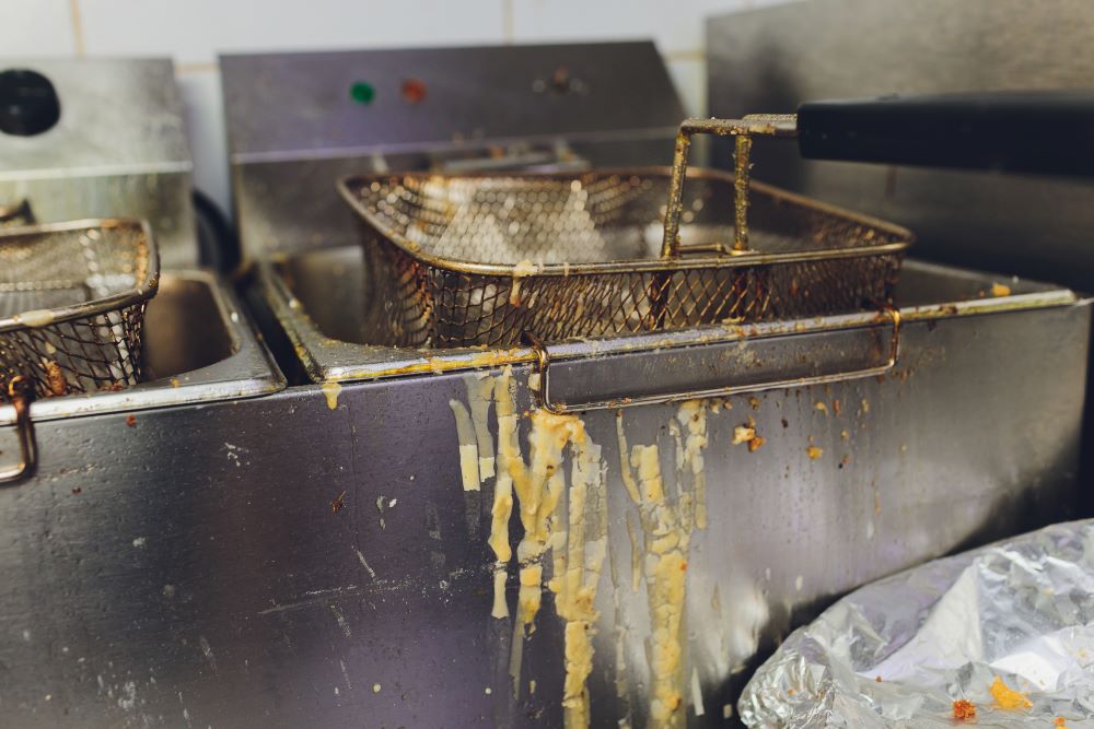 Greasy and oily deep fryer in kitchen