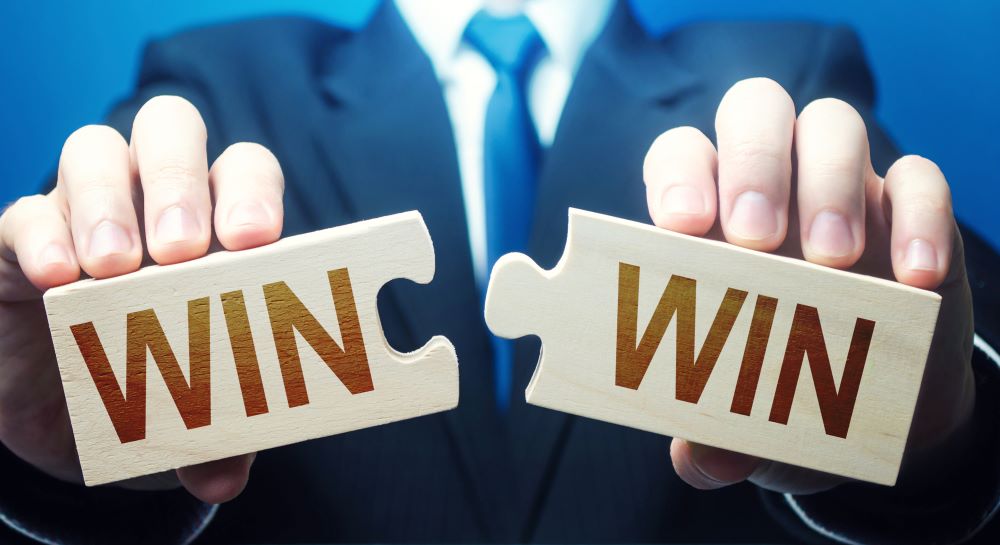Man holding two puzzles with Win-Win words