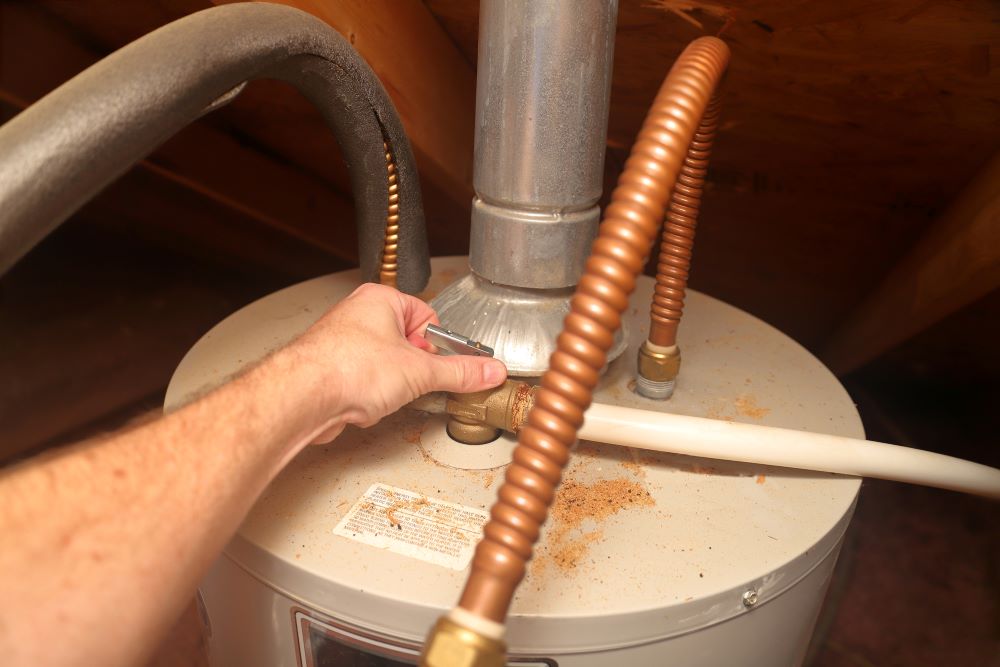 Water Heater - hand releases T&P safety Relief Valve in a home