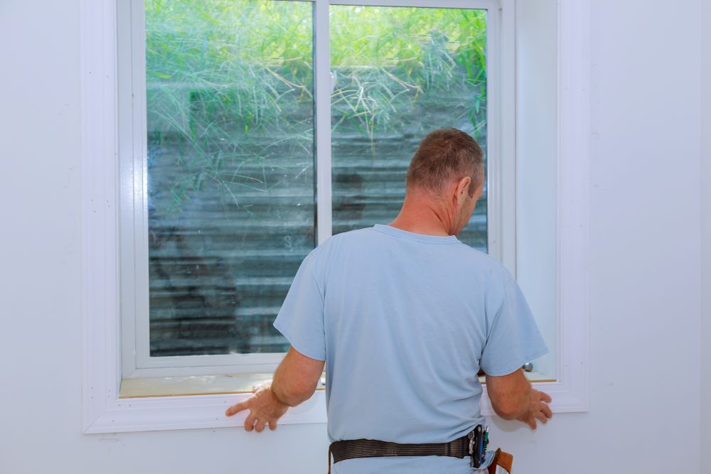 Worker installing trim around a window molding