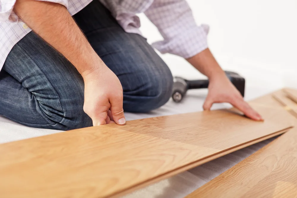 Man laying laminate flooring - closeup on hands

man fixing floors handyman