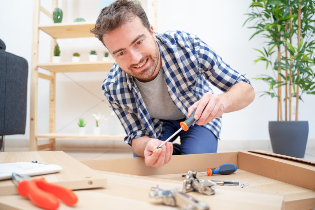 Man assembling furniture at home on the floor