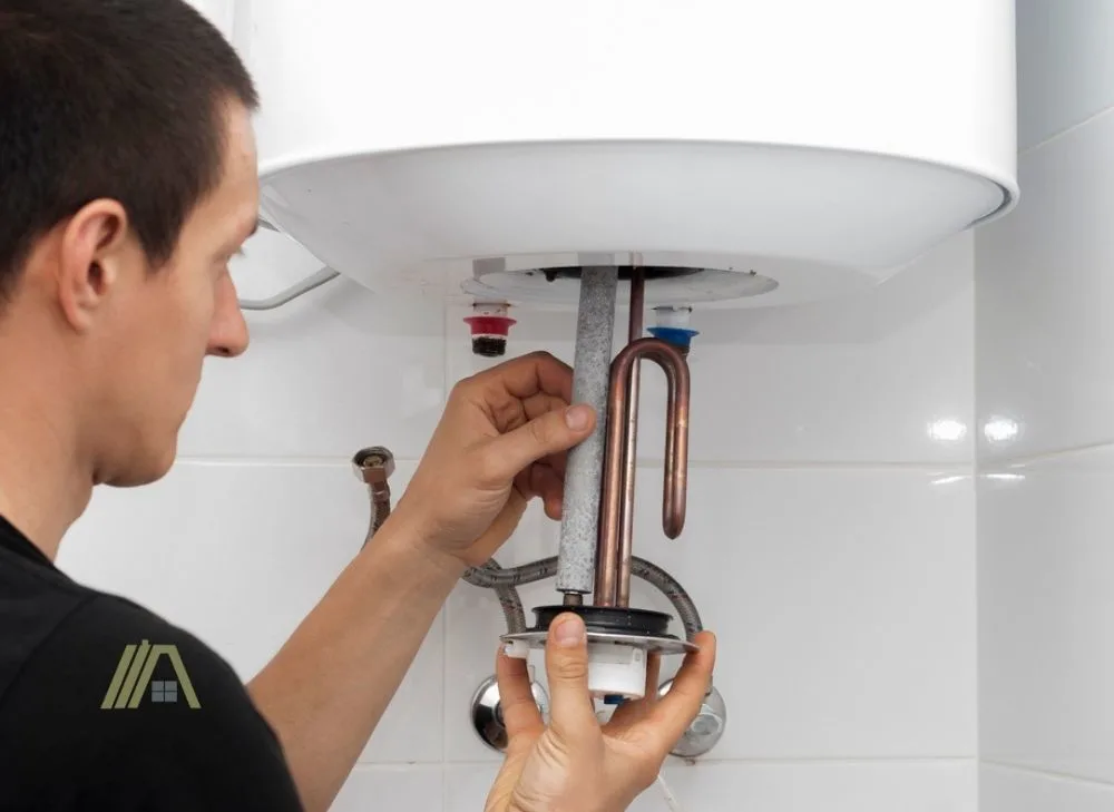 The master repairs the boiler with anode rod in water heater tank
