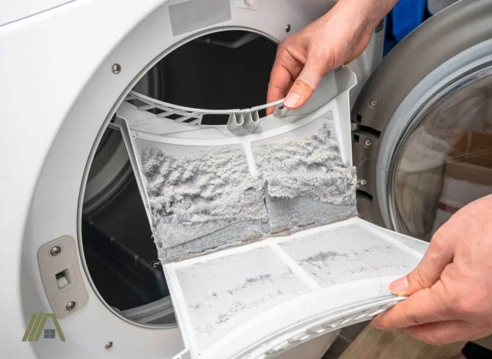 Man holding a lint trap with accumulated lint in a ventless dryer