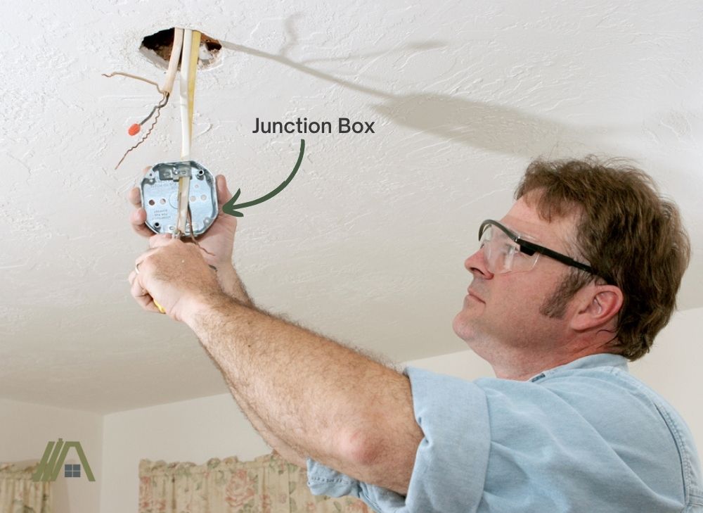 electrician fixing the junction box of a ceiling fan