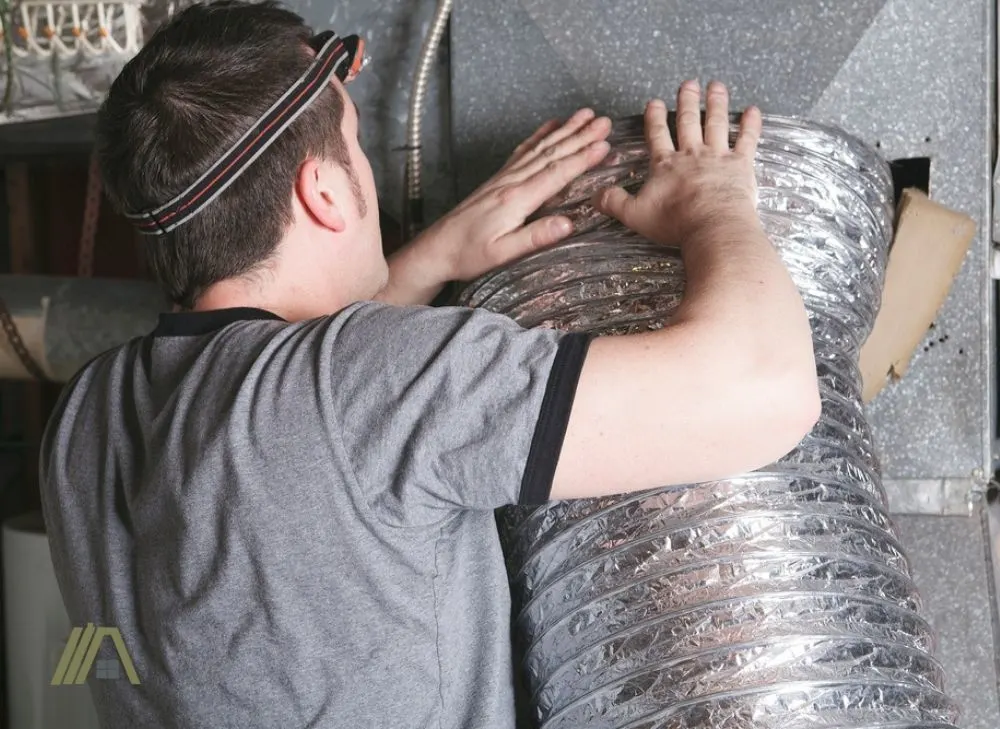Man in gray shirt fixing and compressing flexible duct