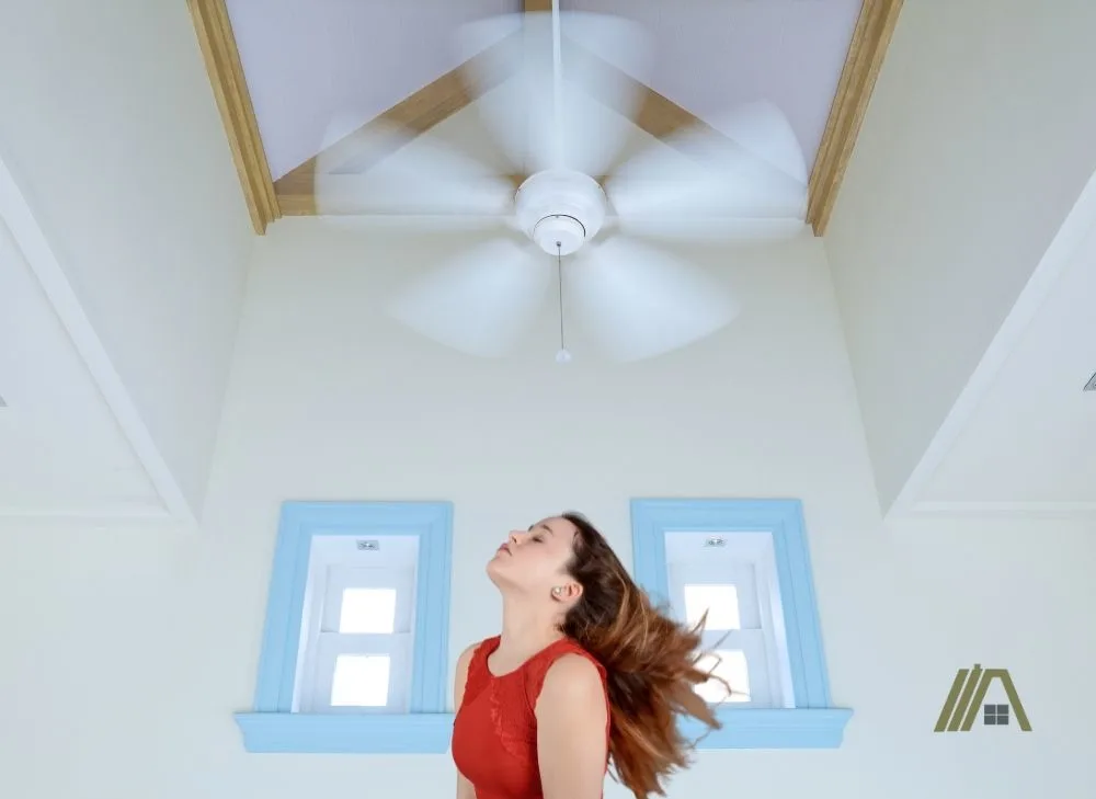 Girls hair blowing while she is below the ceiling fan