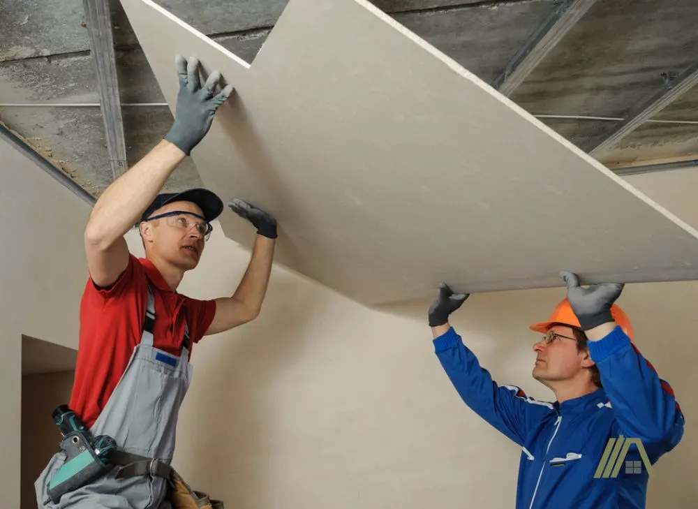 two construction men installing ceiling drywall