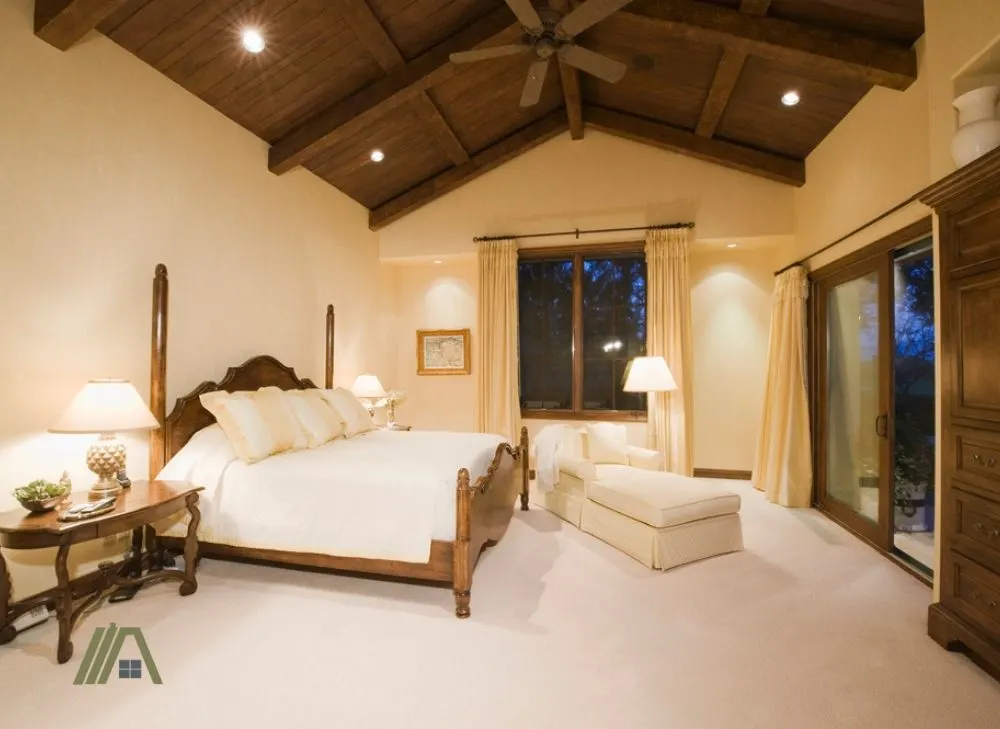 Cozy bedroom with white walls, wooden ceiling and a ceiling fan