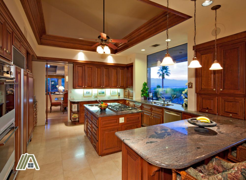 Kitchen with wood cupboards and a ceiling fan on top