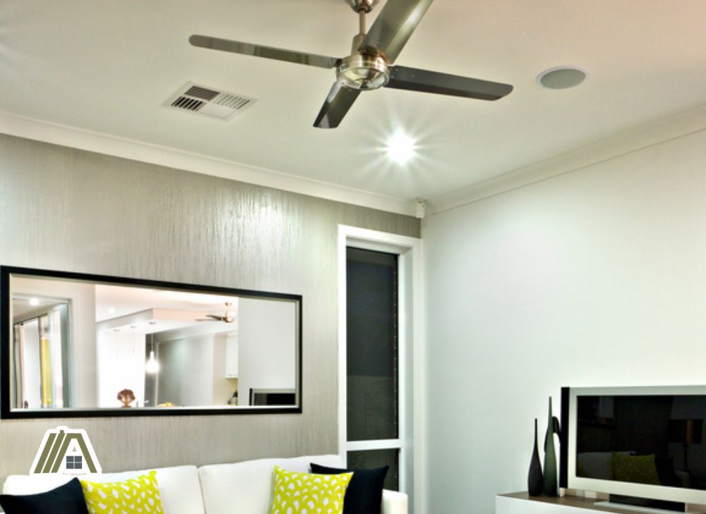 Living room with a silver four bladed ceiling fan and a ceiling vent