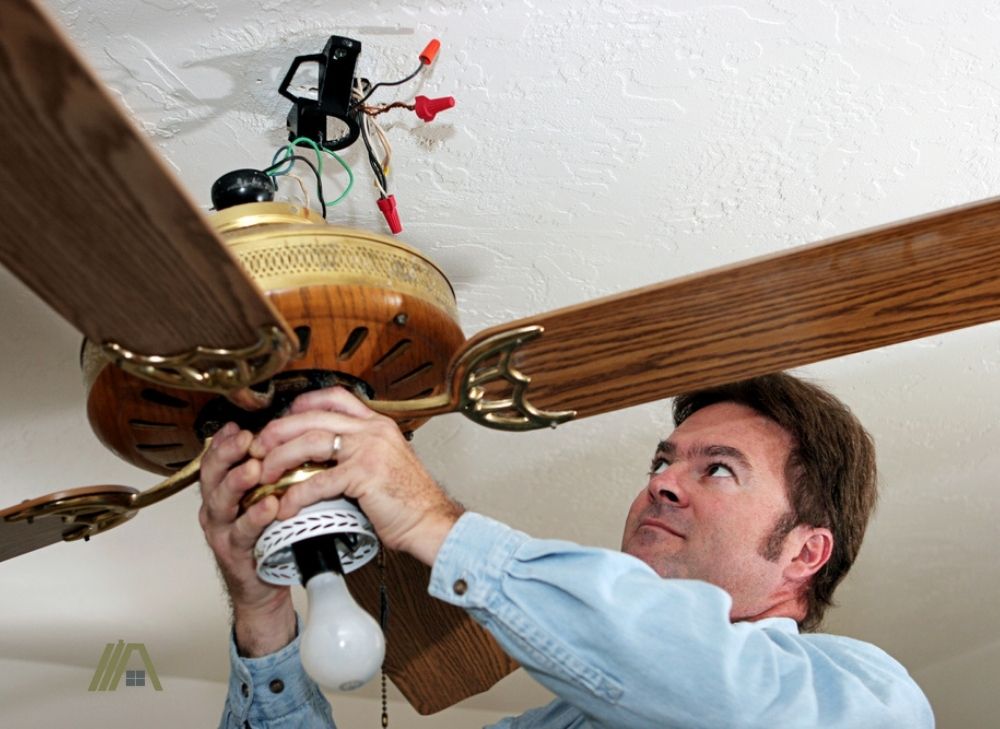 Man checking the wiring of the ceiling fan