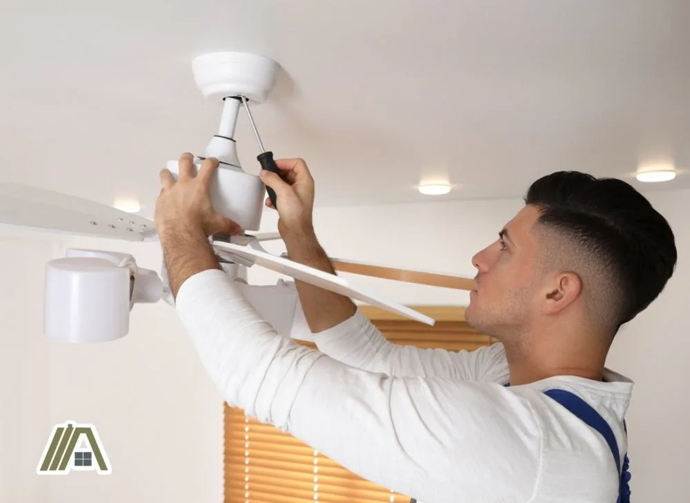 Man unscrewing the canopy of the ceiling fan