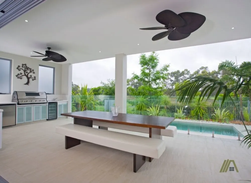 Modern covered backyard with pool and two ceiling fans