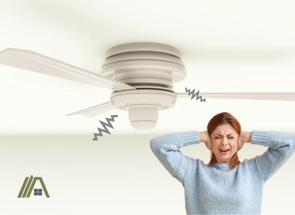 Noisy white hugger or flush mount ceiling fan with woman covering her ears
