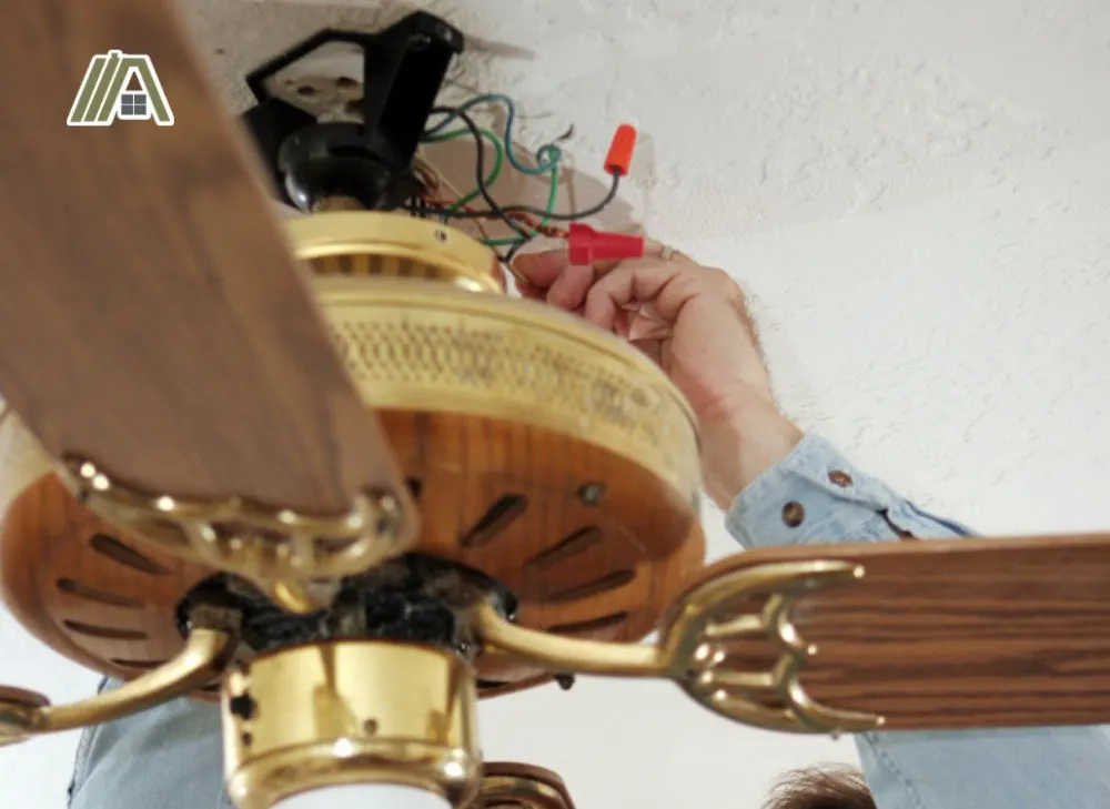 Man repairing the wiring of a ceiling fan