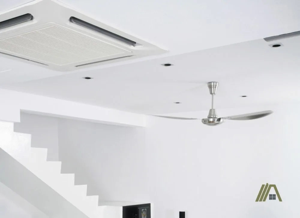 White ceiling with air-conditioning unit and a ceiling fan