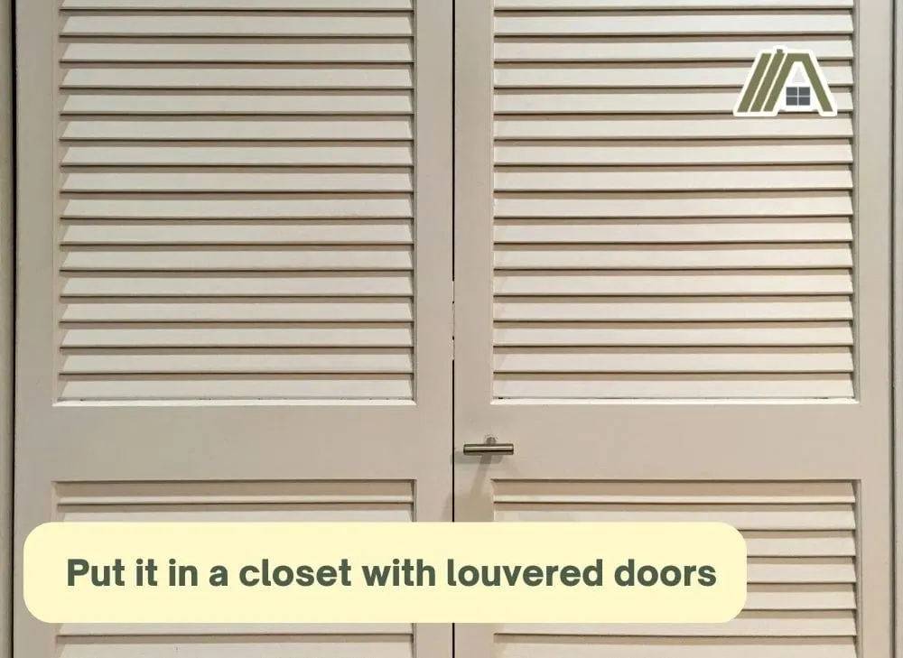 Put it in a closet with louvered doors, white closet with louvered doors