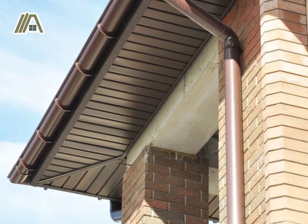 Drain installed on fascia with brown eaves and column with brick façade