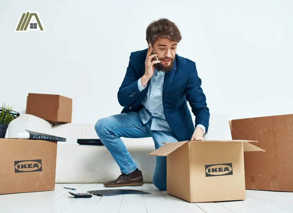 Man opening and inspecting his packages from IKEA while talking to his phone