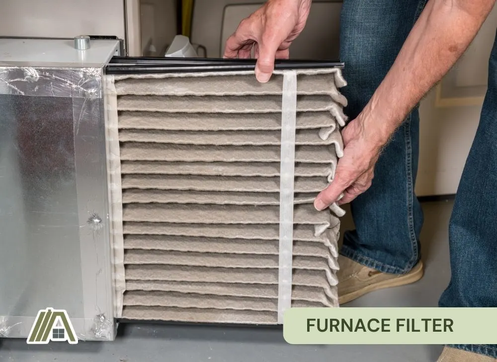 Man-pulling-out-a-dirty-furnace-filter-2