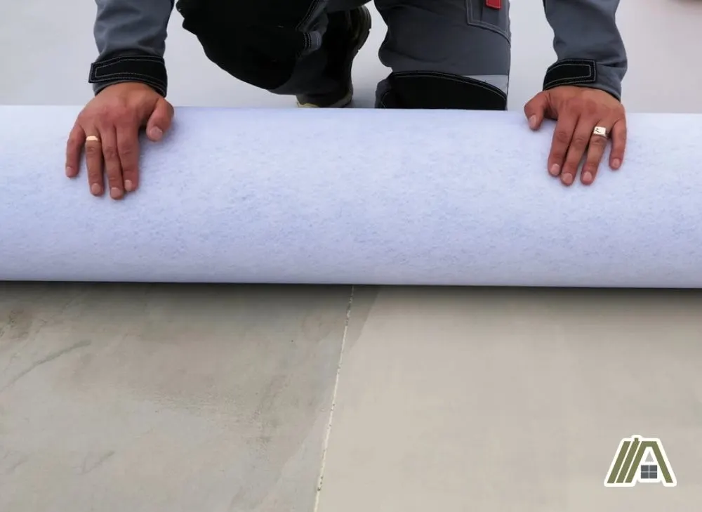 Man rolling out plastic insulation on floor