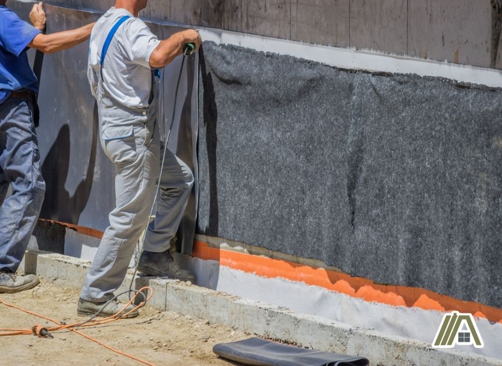 Men installing plastic insulation on wall