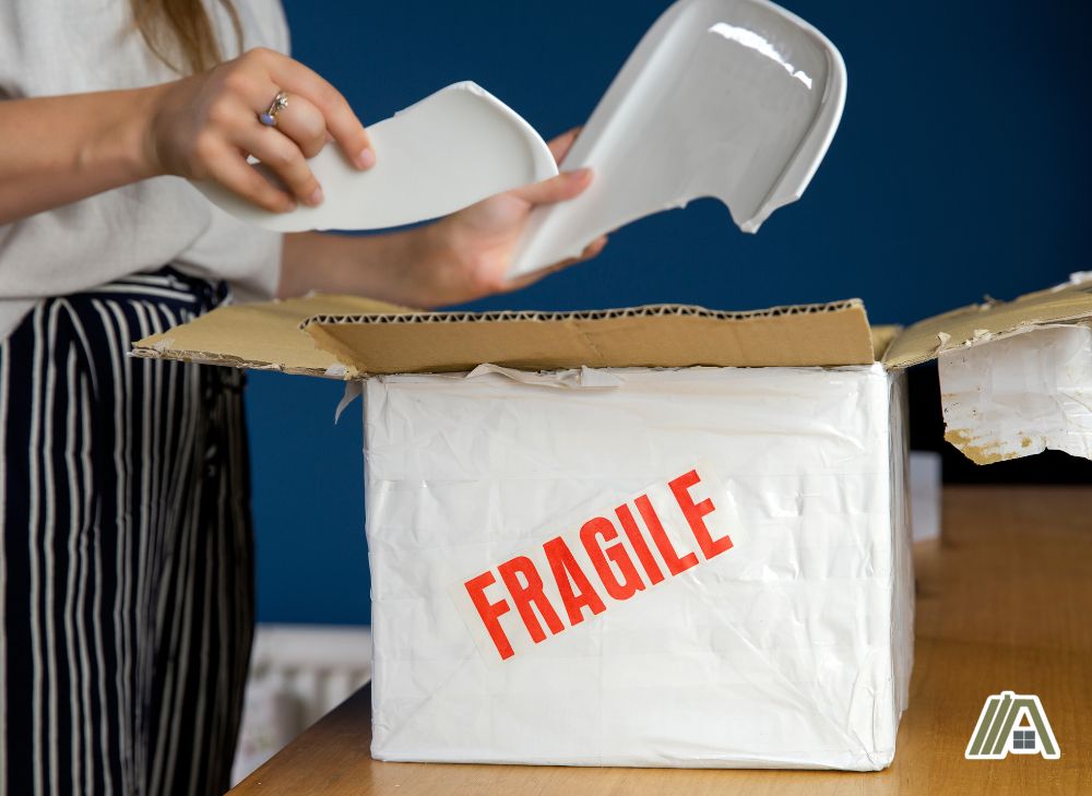 Woman opening a package with damaged item inside