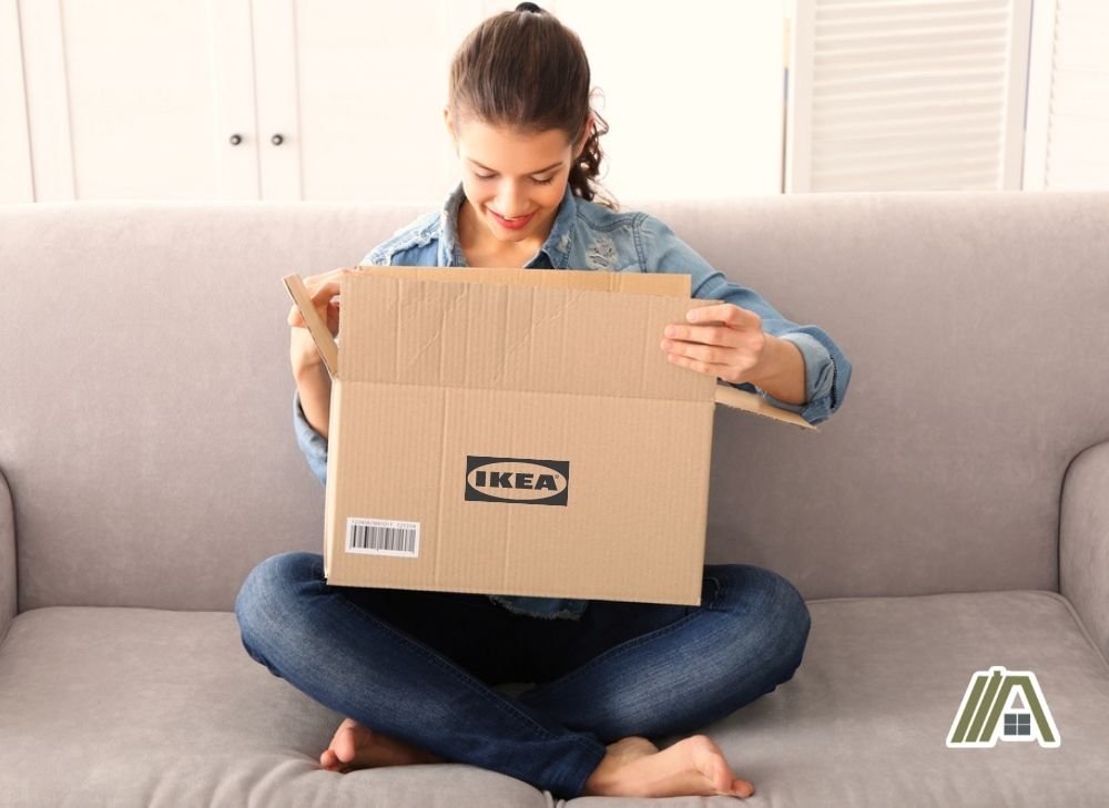 Woman opening and looking at her IKEA package while sitting on the sofa