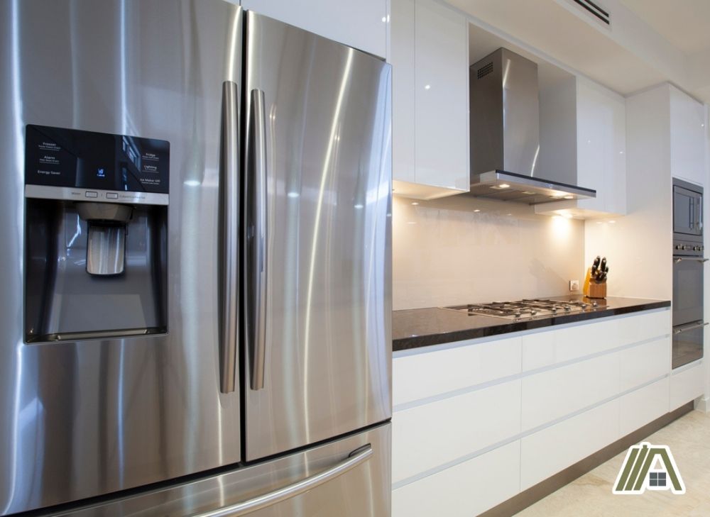 Stainless steel modern double door with water dispenser fridge in a kitchen with stove