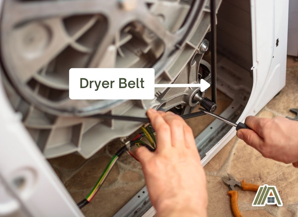 Man fixing the dryer belt of a dryer