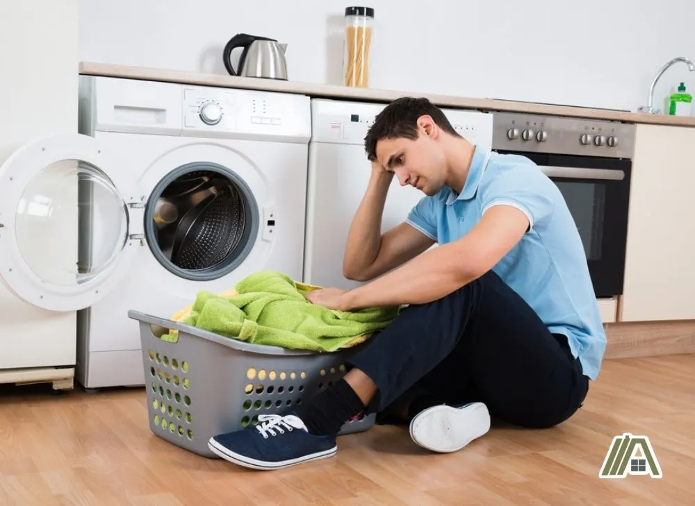 Man worrying and sad doing the laundry