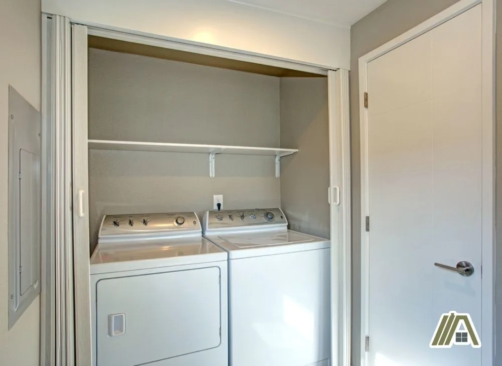 Two-white-gas-dryers-inside-a-closet-with-folding-doors