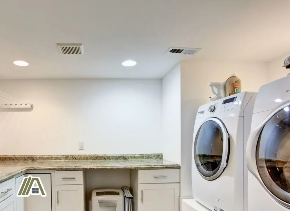 White laundry room with dryer, washer, exhaust and makeup air HVAC system