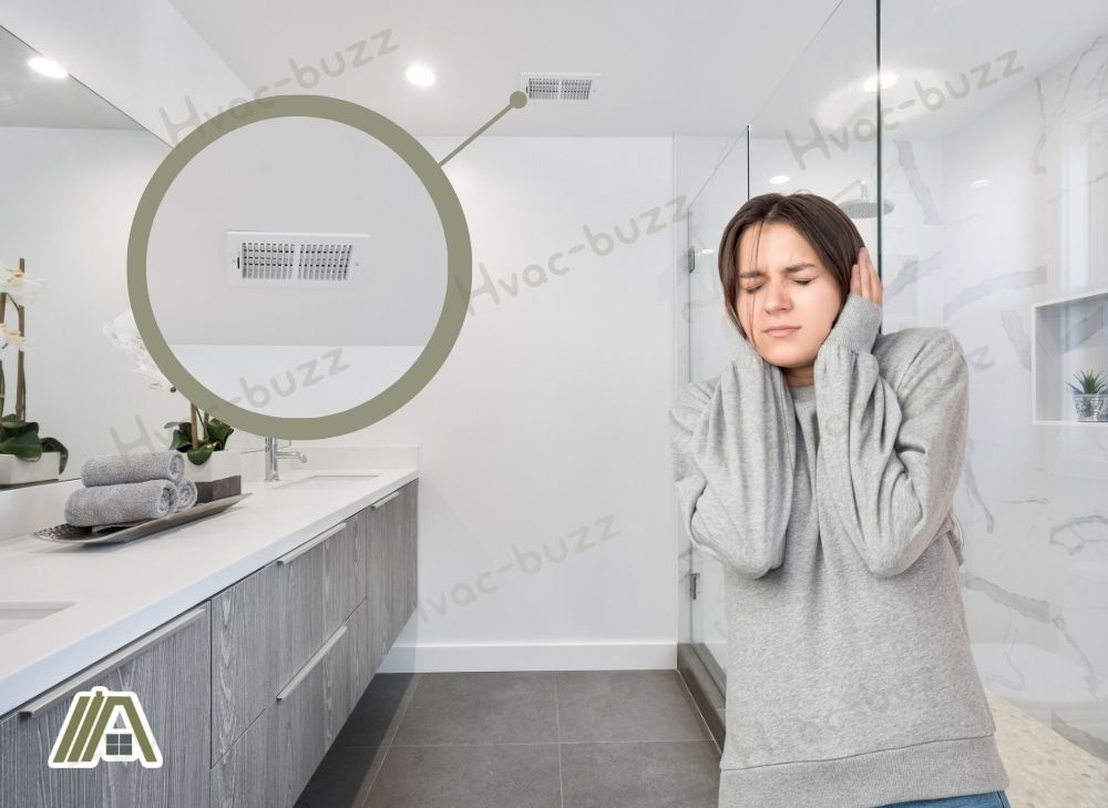 Woman covering her ears due to the noise of the bathroom exhaust fan