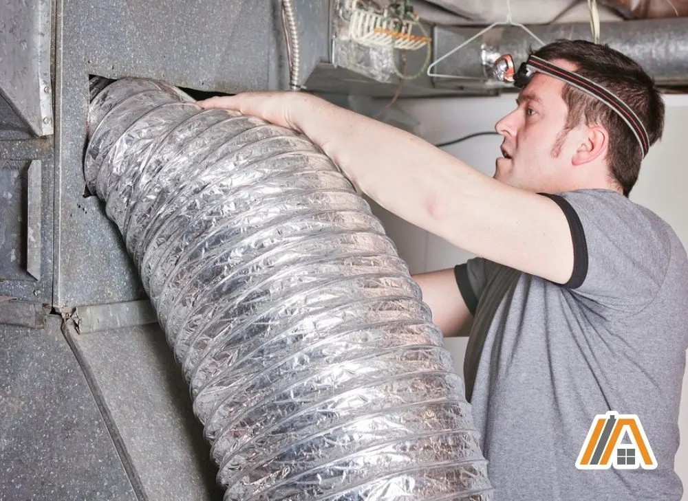 Man compressing the flexible duct into a hole