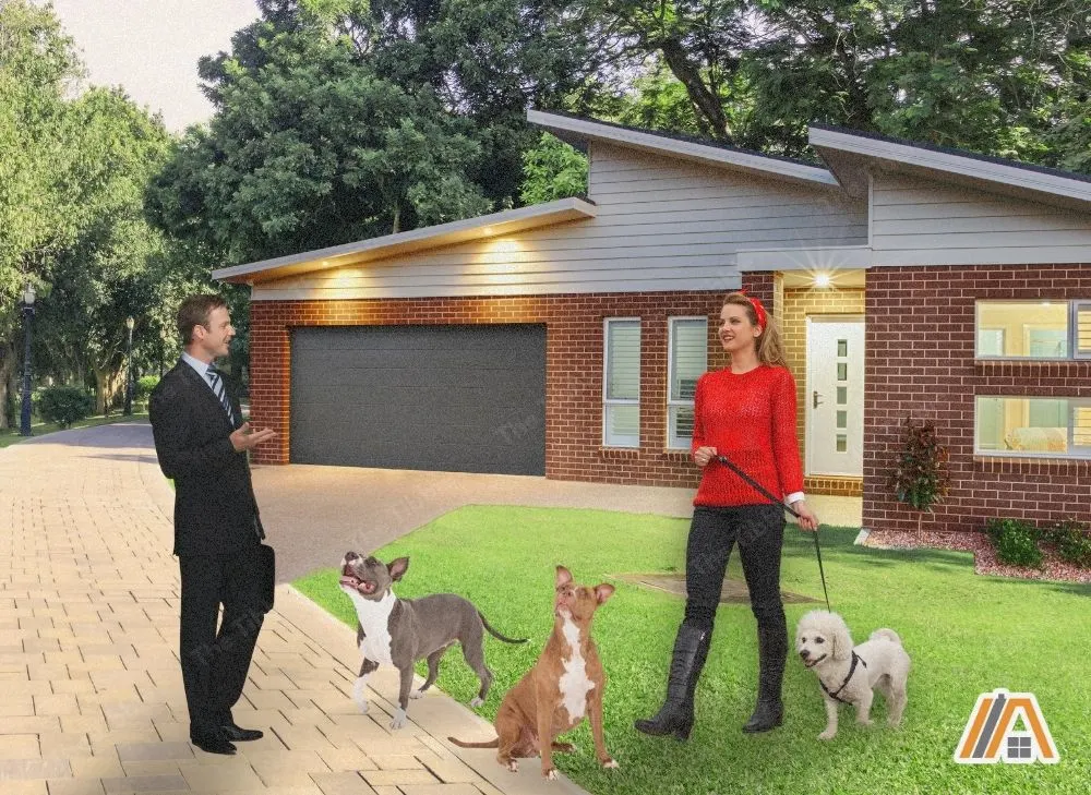Man in a suit talking to a woman with her dogs outside of her house