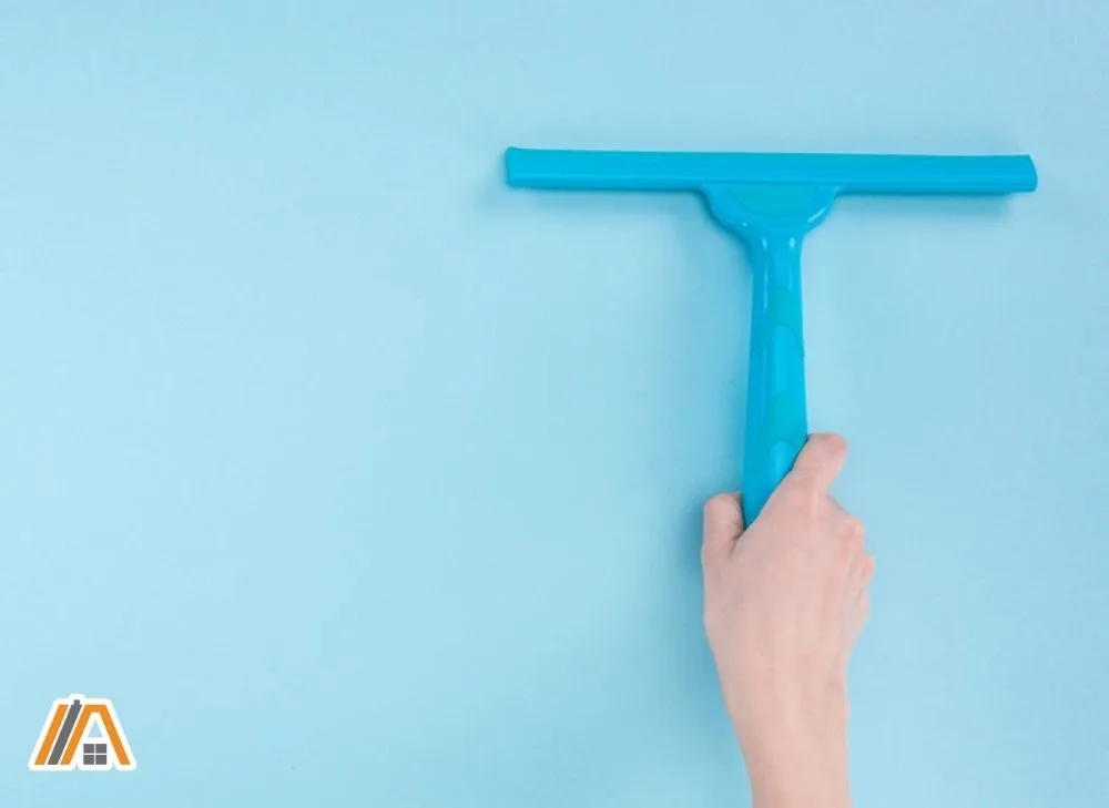 Using a blue squeegee on a blue wall
