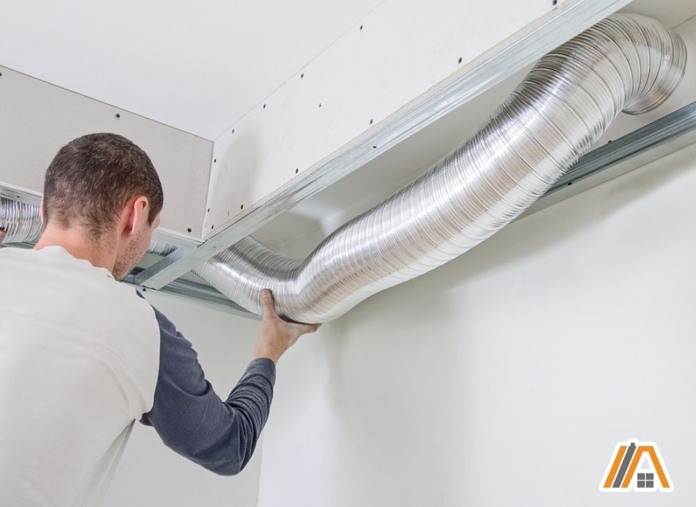 Man checking flexible duct pipe installed in the ceiling