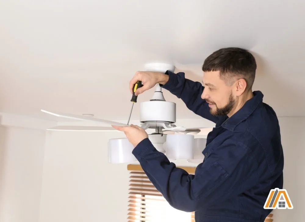 Technician removing screws on the ceiling fan blade